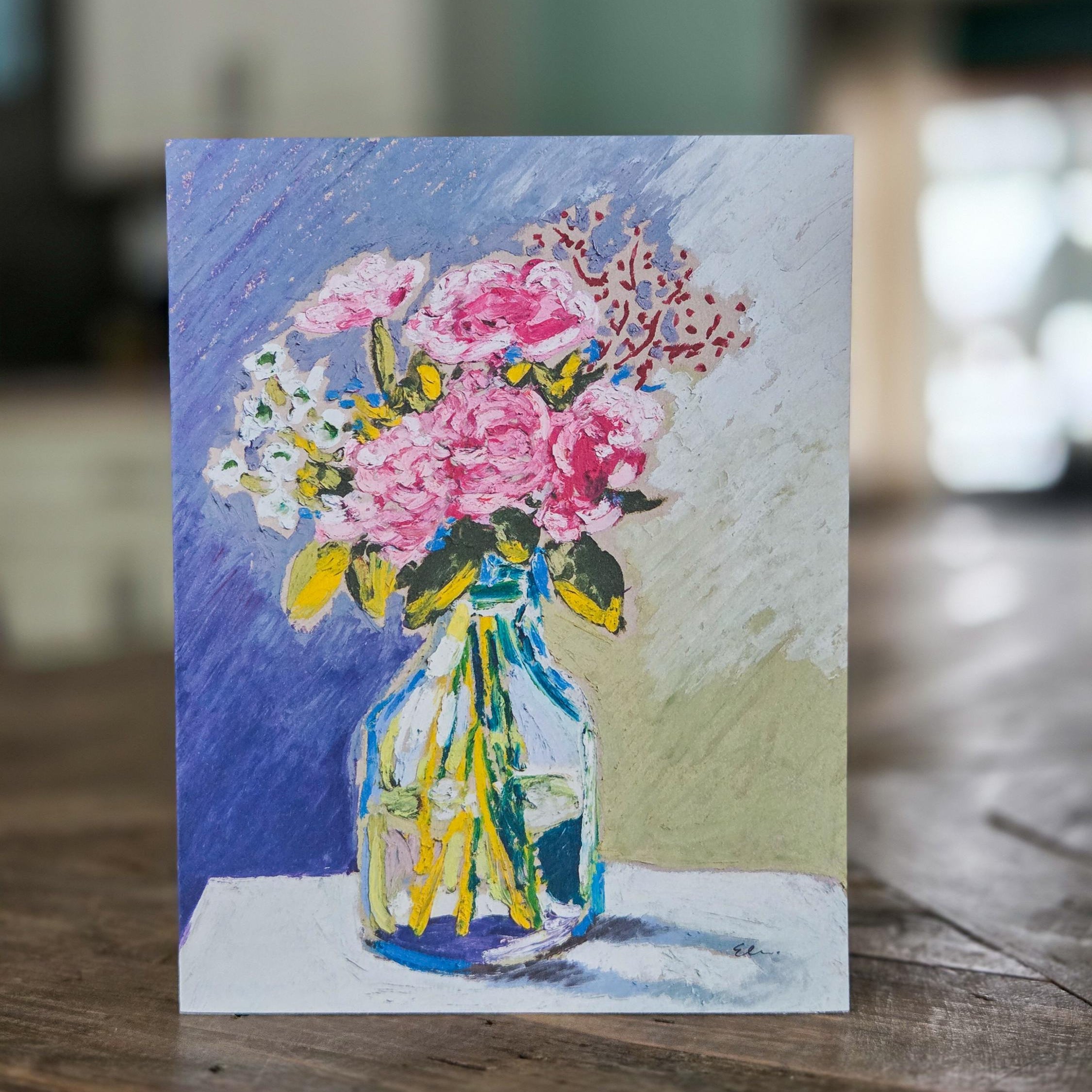 Card with a colorful illustration of flowers and butterflies on a wooden surface.