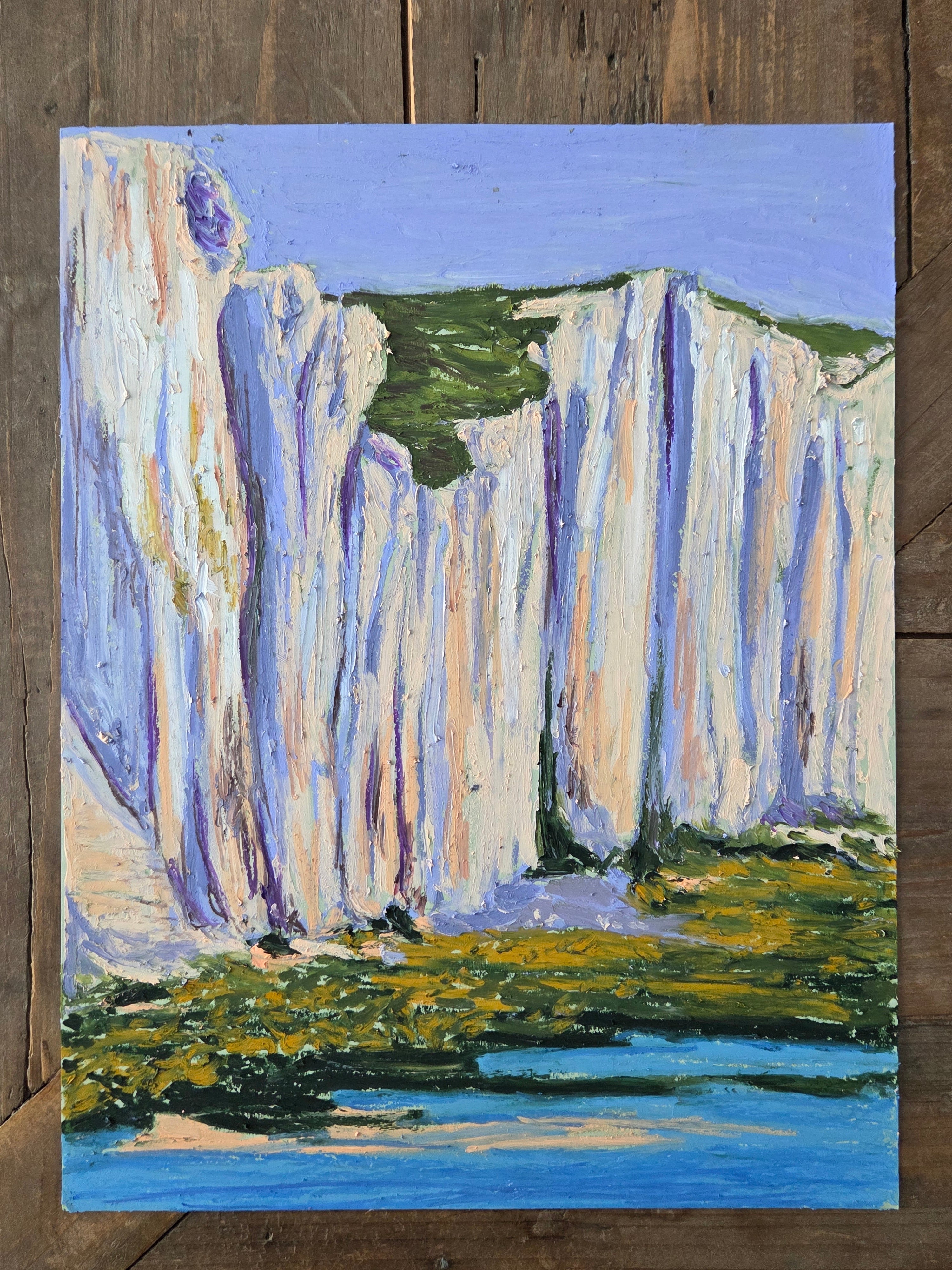 Abstract painting on a wooden surface with blue, green, and white colors.